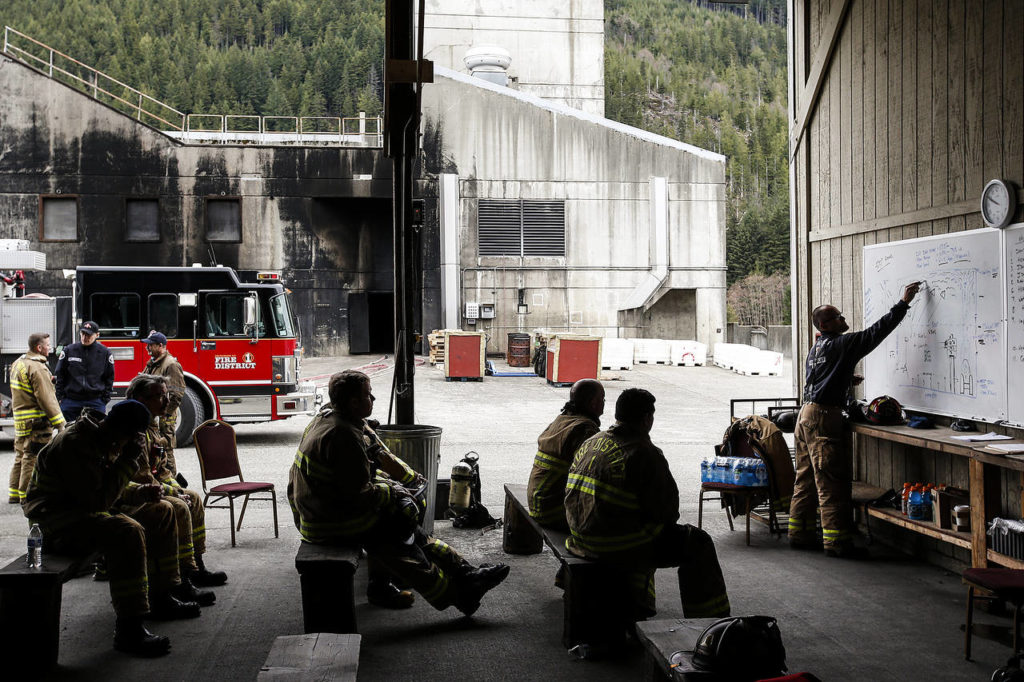 Jason Isotalo (right), captain of Fire District 1, teaches recruits about the stages of fire escalation at the Washington State Fire Training Academy near North Bend on Tuesday. (Ian Terry / The Herald)
