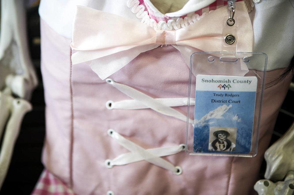 A work identification badge hangs from Trudy Rodgers, a skeleton seated at the Snohomish County District Court office. (Ian Terry / The Herald)
