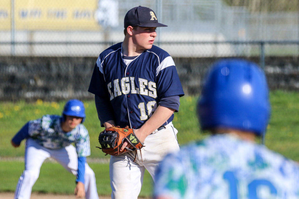 Arlington’s Tristan Sheward eyes the batter with Shorewood runners waiting during a game April 21, 2017, in Arlington on April 21, 2017. (Kevin Clark / The Herald)
