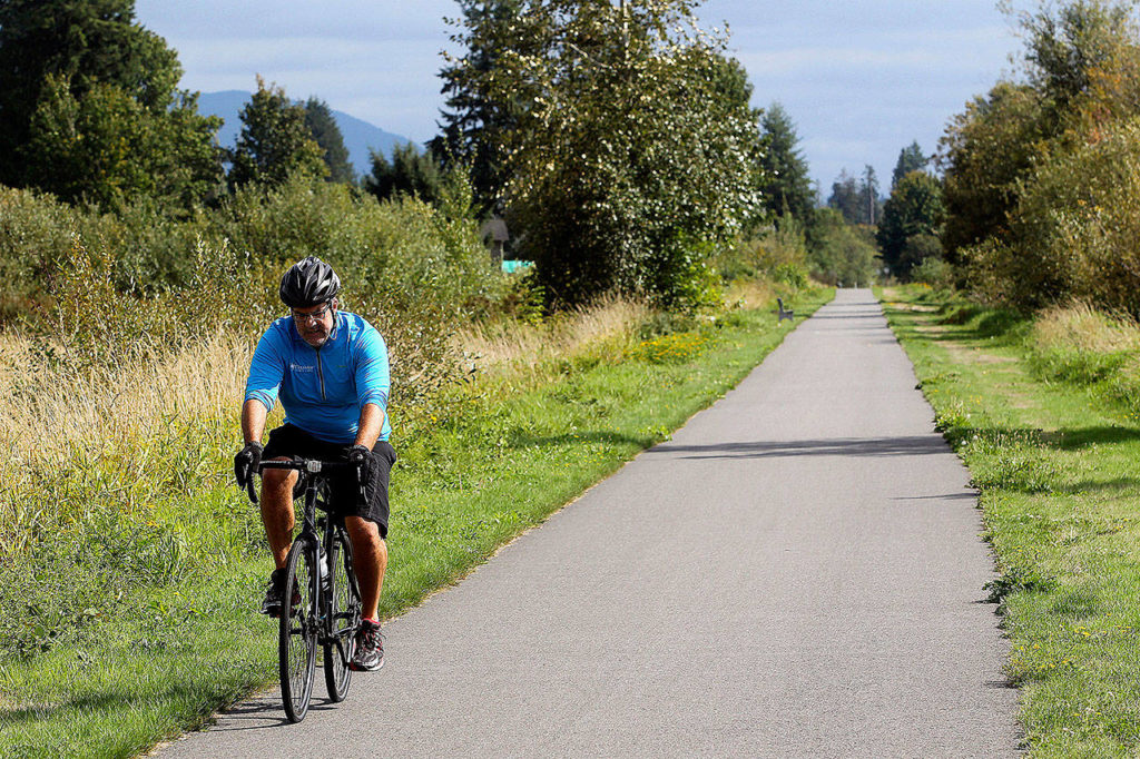 Nick Ridgeway, of Stanwood, bikes down the Centennial Trail outside of Bryant. He and his family walk and bike on the trail often. (Genna Martin / Herald file)
