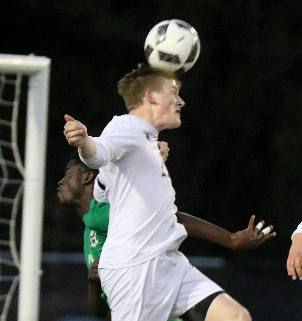 Snohomish’s Jason Fairhurst heads the ball for a goal over Edmonds-Woodway’s Njaka Jammeh during a game April 20, 2017, at Memorial Stadium in Snohomish. (Kevin Clark / The Herald)
