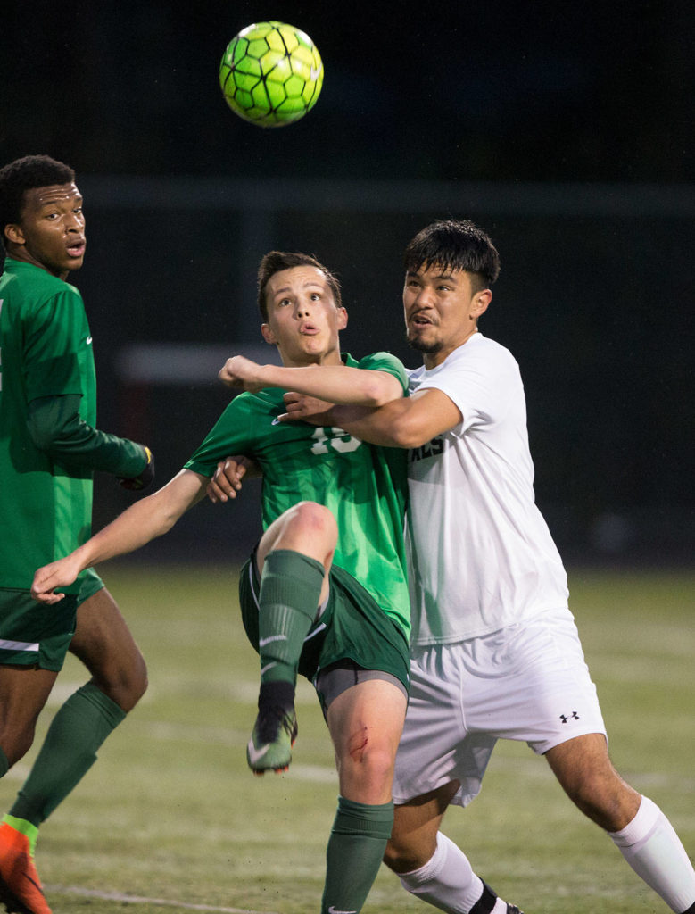 Lynnwood’s Diego Aragon (right) grabs Edmonds-Woodway’s Kyle Aure as they battle for the ball during a game on April 5, 2017, in Bothell. (Andy Bronson / The Herald)
