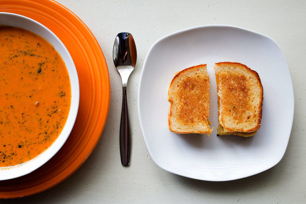 Tomato soup is the perfect partner with a grilled sandwich, which can be made with any variety of cheeses and breads. Don’t be shy — dip the sandwich in the soup. (Andy Bronson / The Herald)
