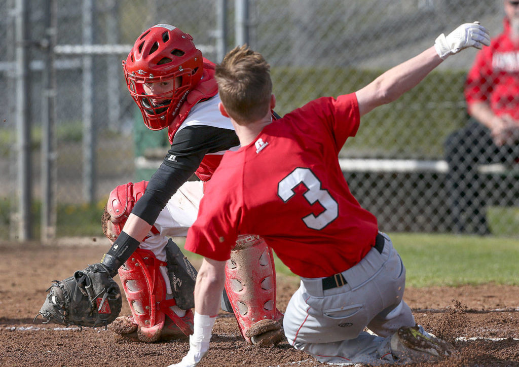 Snohomish catcher Logan Gates looks to tag out Marysville Pilchuck’s Jacob Watts during a game April 18, 2017, in Snohomish. (Andy Bronson / The Herald)
