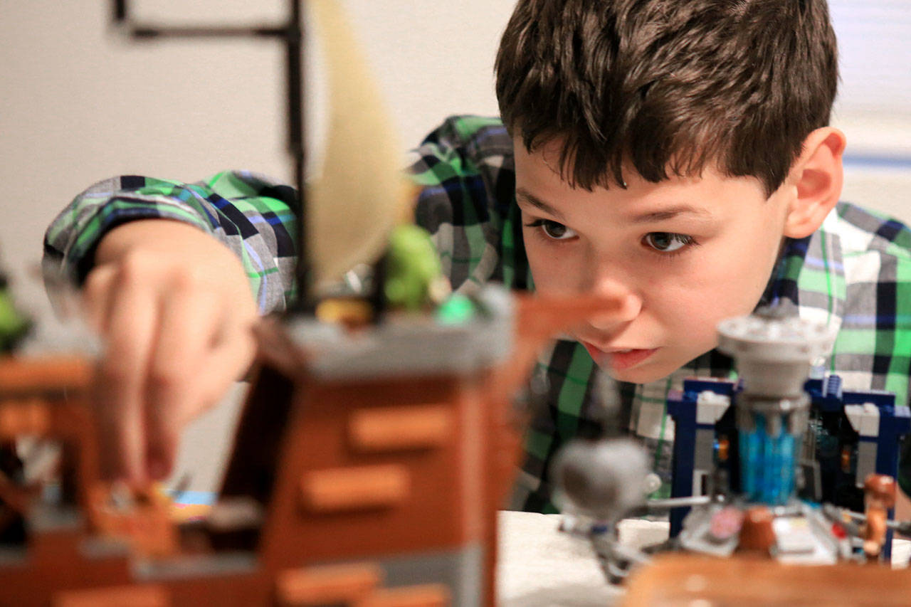J.T. Fisher, 11, plays with Legos. Like his younger brother Colin, J.T. lives with autism. (Kevin Clark / The Herald)