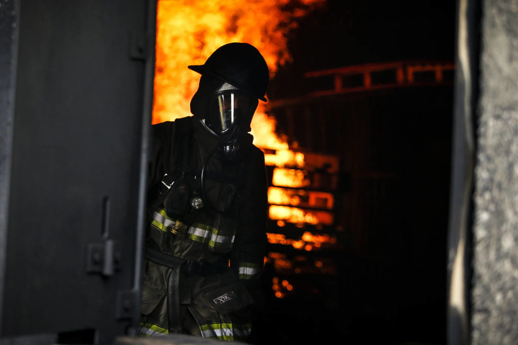 A firefighter walks through a building during an exercise at the Washington State Fire Training Academy near North Bend on Tuesday. (Ian Terry / The Herald)

