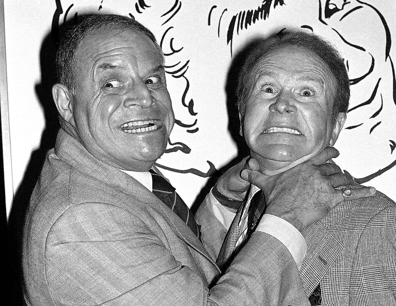 In this Nov. 10, 1977 photo, comedian Don Rickles (left) pretends to strangle fellow comedian Red Buttons prior to an Annual Stag Roast in Los Angeles. (AP Photo/ Lennox McLendon, File)