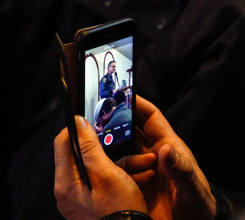 With a cellphone camera, a man records then-acting Lynnwood Police Chief Tom Davis speaking at the Evergreen Islamic Institute earlier this year. (Dan Bates / The Herald)
