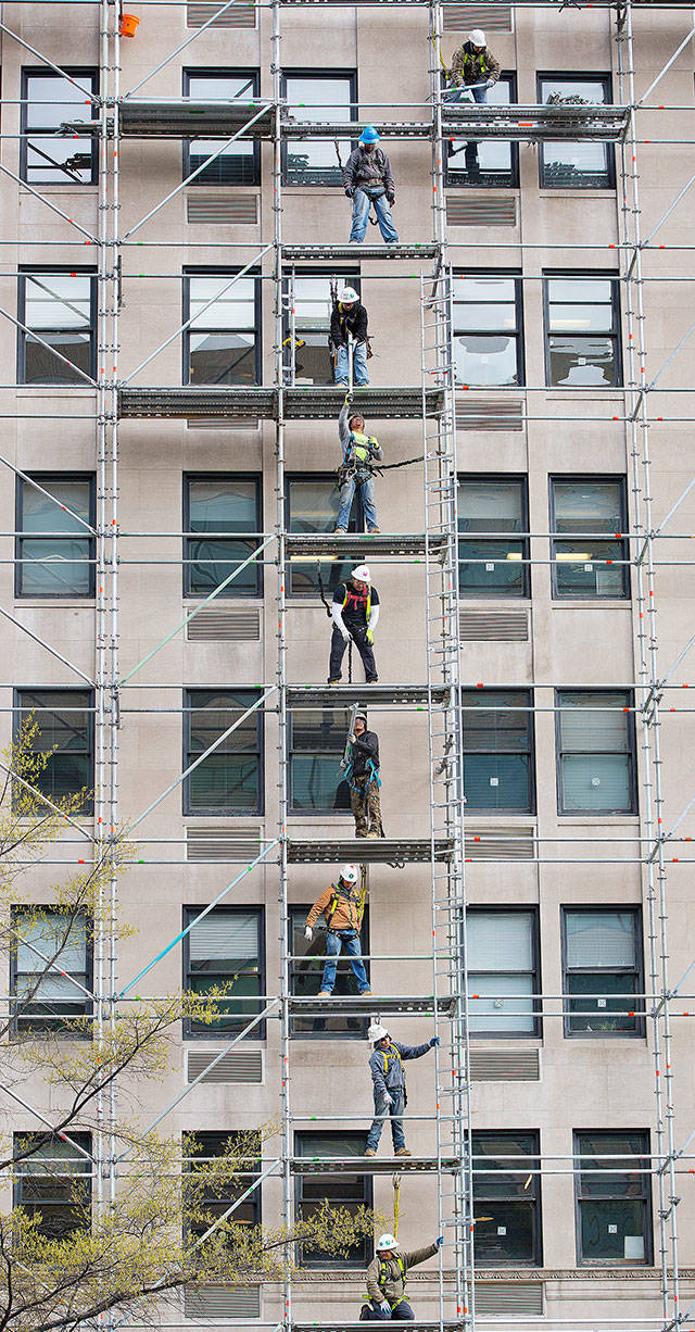 Construction workers assemble scaffolding during renovations on an office building in downtown Washington on Friday. (AP Photo/Pablo Martinez Monsivais)