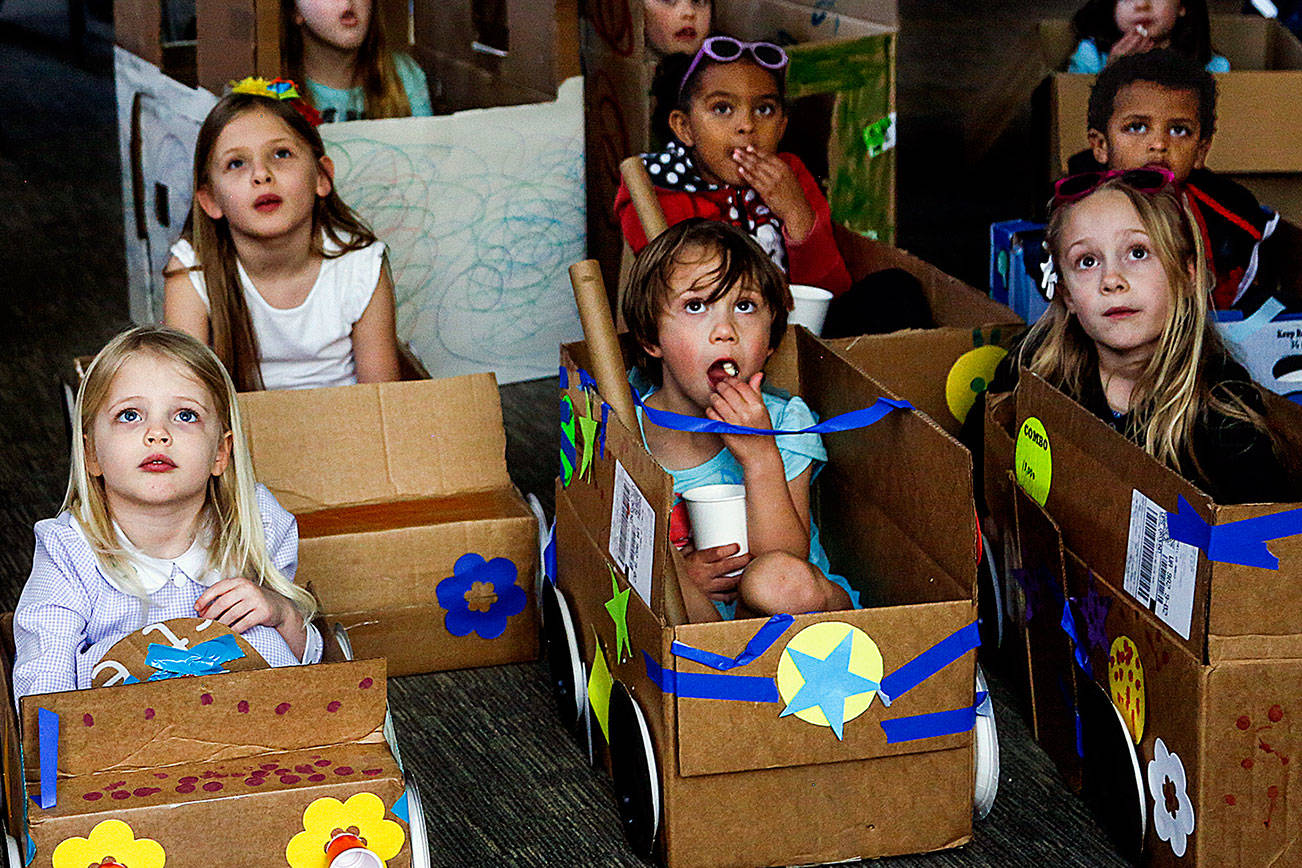 Snohomish area children enjoy watching movies, Monday afternoon at the Snohomish Library’s “My First Drive-in” event. The youngsters, 3-years and older brought cardboard boxes from home and used their arts and crafts skills to transform them into pretend cars to sit in while watching a selection of movie shorts that included Mike’s New Car, The Present, Feast and Lava. (Dan Bates / The Herald)