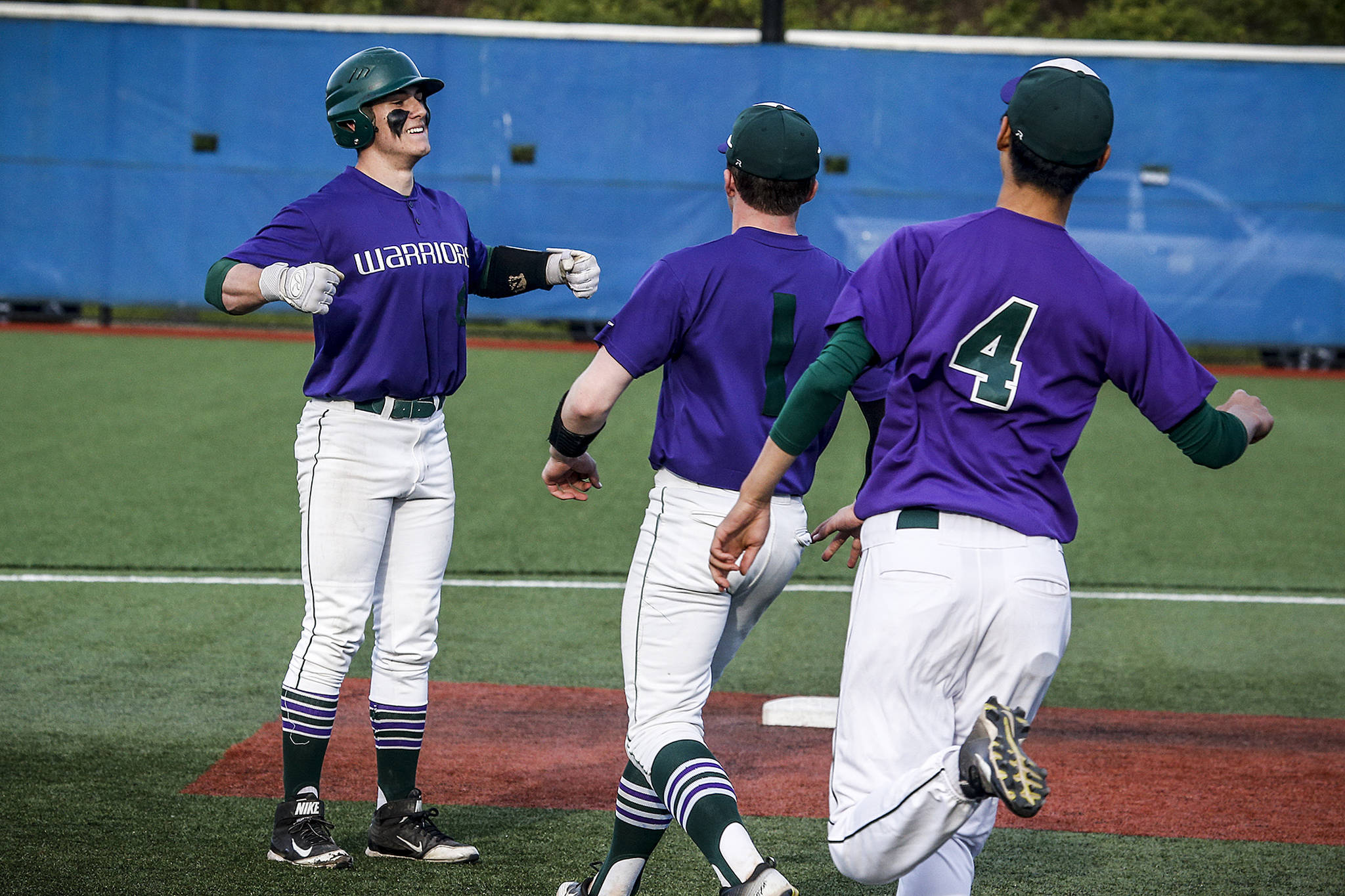 Edmonds-Woodway’s Brandon Mitchell (left) celebrates his walk-off hit in the bottom of the ninth inning of a 3A District 1 semifinal game against Snohomish on May 9, 2017, at Meridian Park Fields. (Ian Terry / The Herald)