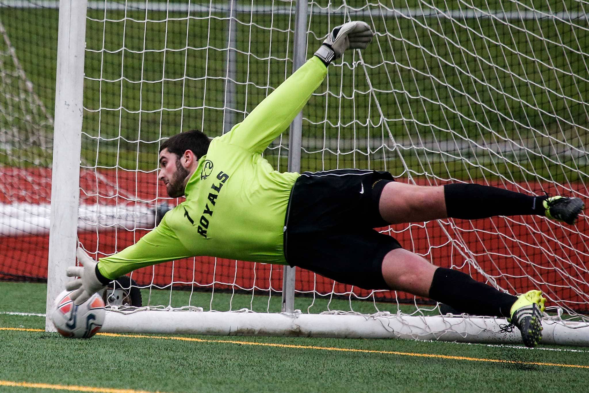 Lynnwood goalkeeper Tyler Stull makes a diving attempt to stop a penalty shot goal during a first-round state 3A playoff game against Roosevelt at Edmonds Stadium on May 17. (Ian Terry / The Herald)