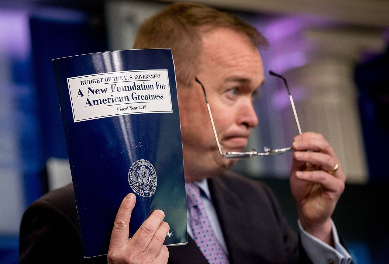 White House Budget Director Mick Mulvaney holds up a copy of President Donald Trump’s proposed 2018 federal budget as he speaks to members of the media in the Press Briefing Room of the White House in Washington, D.C., Tuesday. (Associated Press)