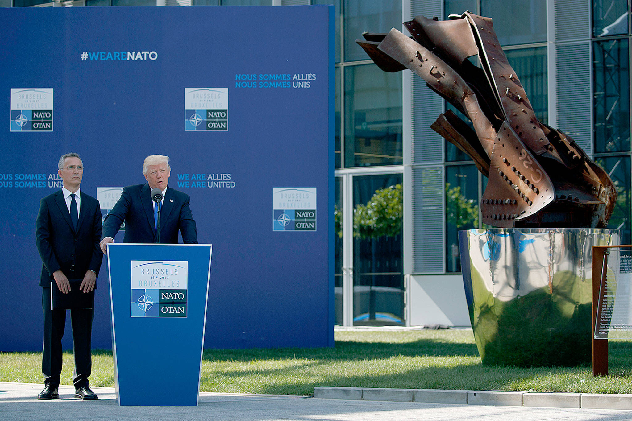 NATO Secretary General Jens Stoltenberg listens as President Donald Trump speaks during a ceremony to unveil artifacts from the World Trade Center and Berlin Wall for the new NATO headquarters on Thursday in Brussels. (AP Photo/Evan Vucci)