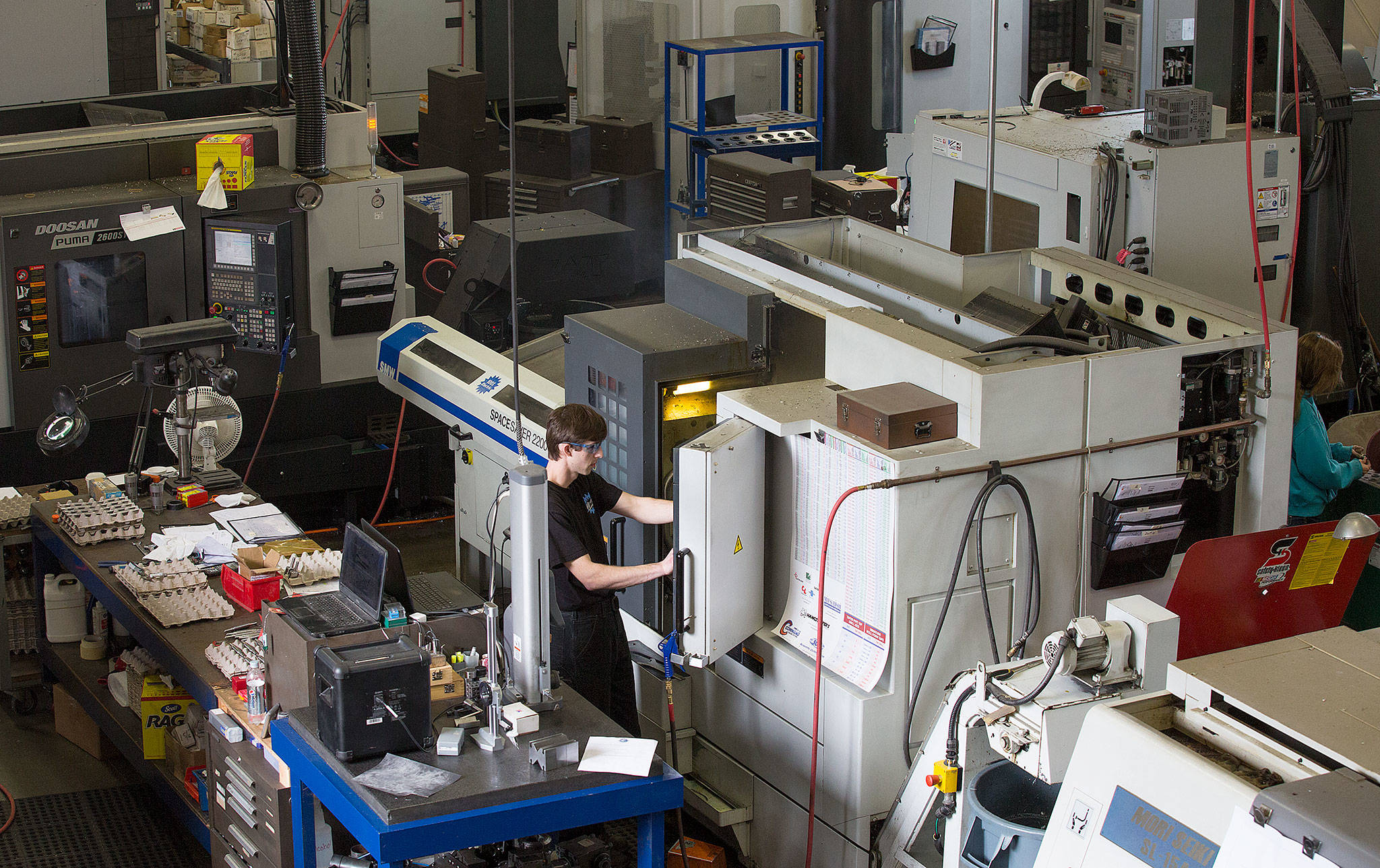 Surrounded by machines worth hundreds of thousand of dollars, C&C machinist Todd Hardman programs a machine to mill a clevis at Cobalt Enterprises’ new building Wednesday in Lake Stevens. (Andy Bronson / The Herald)