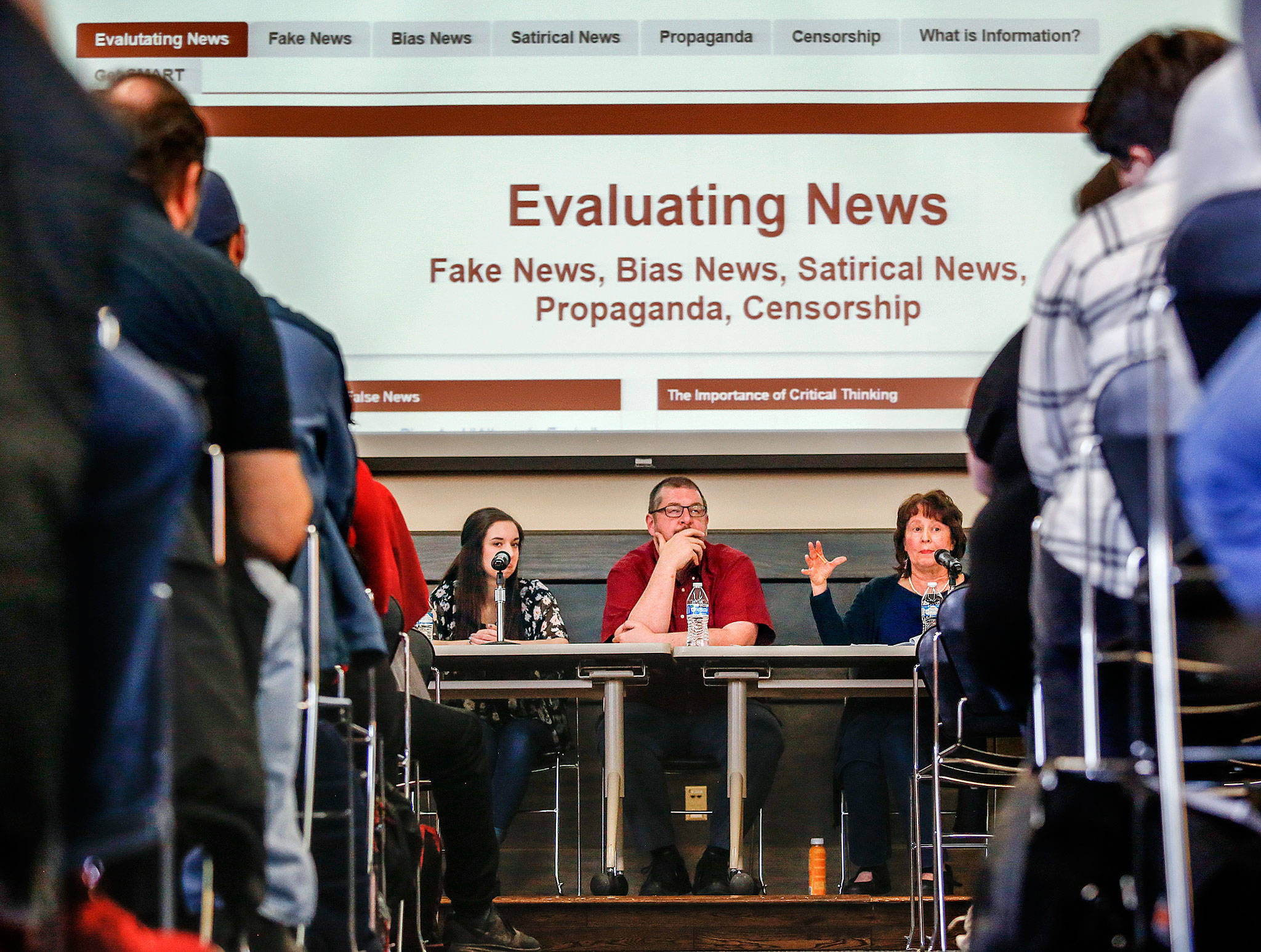 EvCC Clipper Editor Abby Tutor and journalism instructor T. Andrew Wahl listen as librarian Teresa Jones responds to a question from the crowd Tuesday in the Henry M. Jackson Center’s Wilderness Room, which was packed for the panel discussion about fake news. (Dan Bates / The Herald)
