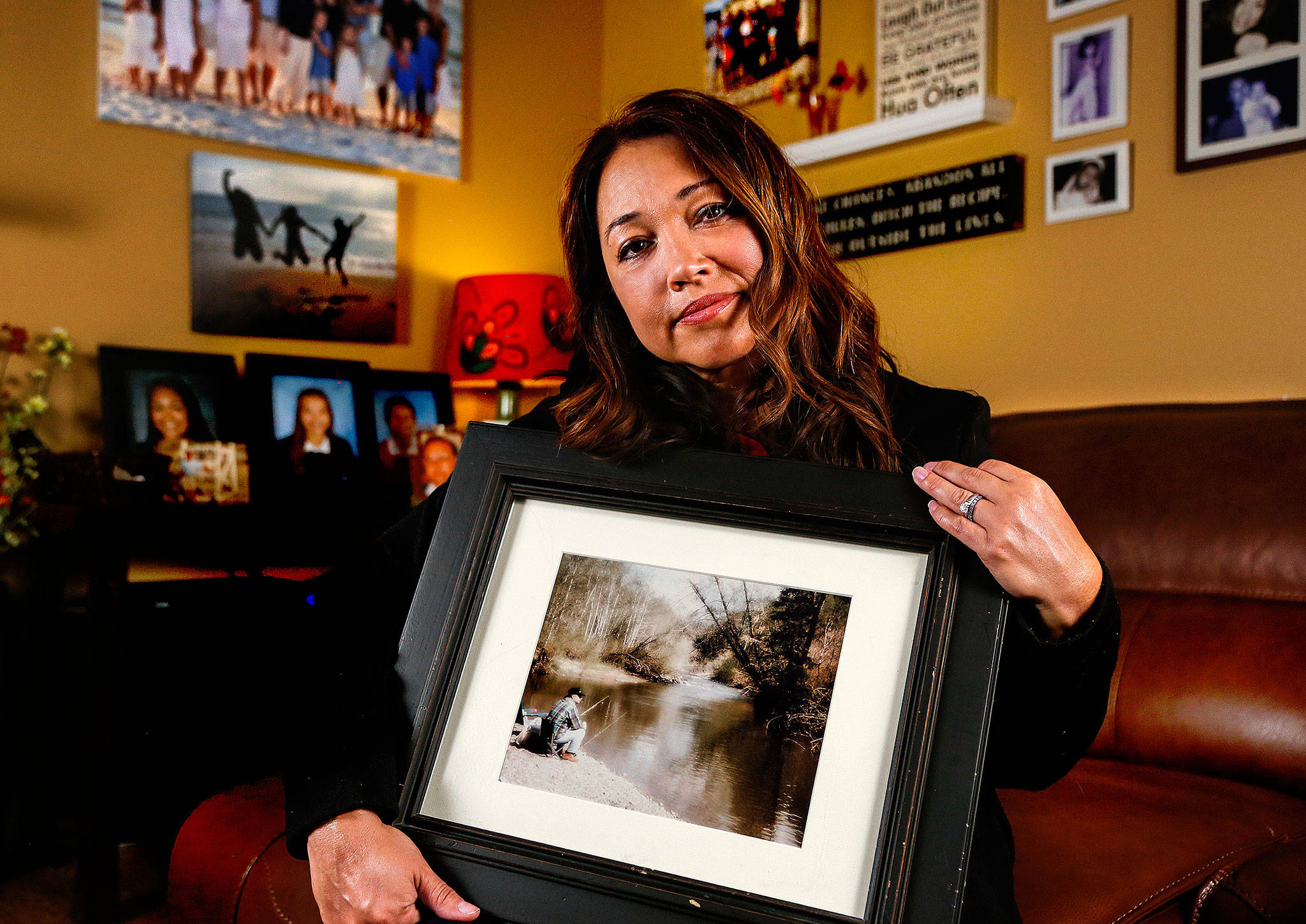 Mayume Carelli’s home is filled with images of the people she loves, including the one she is holding of her dad, Dan Varnell, at his favorite fishing hole on the Pilchuck River. It is where he was murdered by Gail Brashear in 1996. (Dan Bates / The Herald)