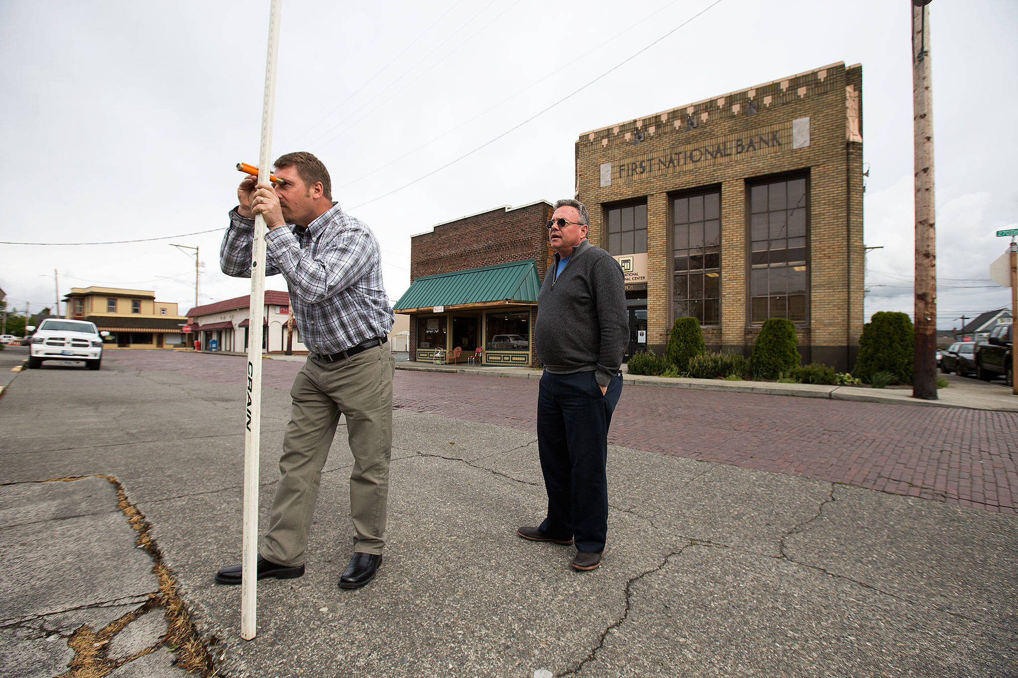 Landscape Architecture’s Scott Lankford teaches Lee Ohlde how to shoot elevation measurements along 270th St. NW, one of many areas of Stanwood that lie in the flood zone, on Monday, May 15, 2017 in Stanwood, Wa. (Andy Bronson / The Herald)