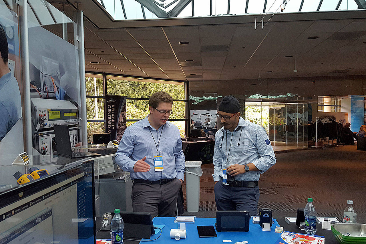 Two participants in Fluke Roadshow 2017 talk outside a booth set up in the lobby of the Fluke campus in Everett. The roadshow was an opportunity to talk about connectivity and smart maintenance in factories. (Contributed photo)