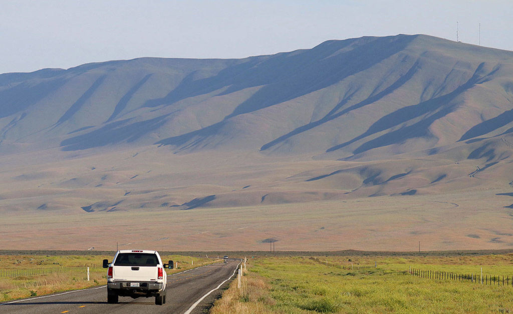 A vehicle drives by a mountain neighboring the Hanford Nuclear Reservation near Richland on Tuesday. A portion of an underground tunnel containing rail cars filled with radioactive waste collapsed at Hanford, forcing an evacuation of some workers at the site that made plutonium for nuclear weapons for decades after World War II. (AP Photo/Manuel Valdes)
