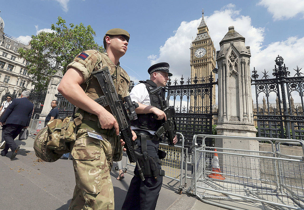 A member of the army joins a police officer to patrol London on Wednesday. (AP Photo/Tim Ireland)