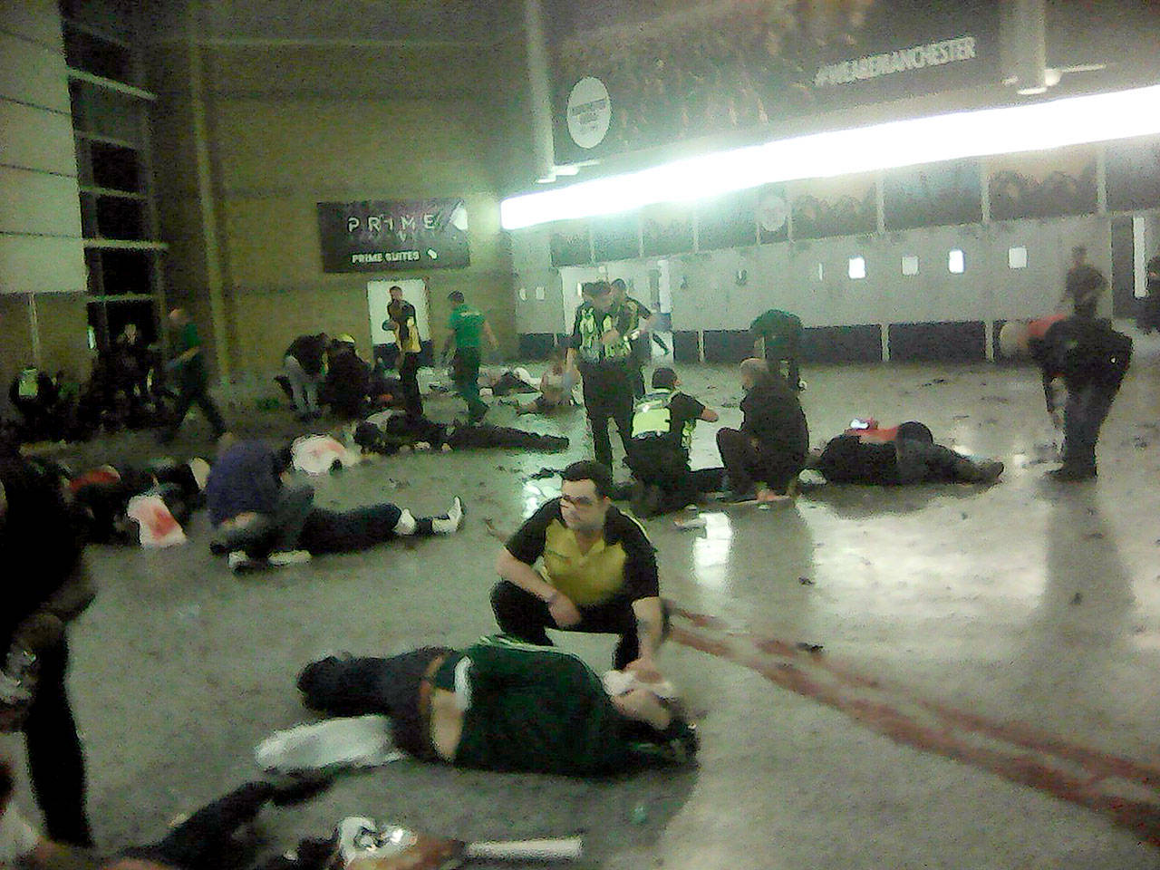 Helpers attend to injured people inside the Manchester Arena in Britain after a blast on Monday caused by an apparent suicide bomber. (PA via AP)