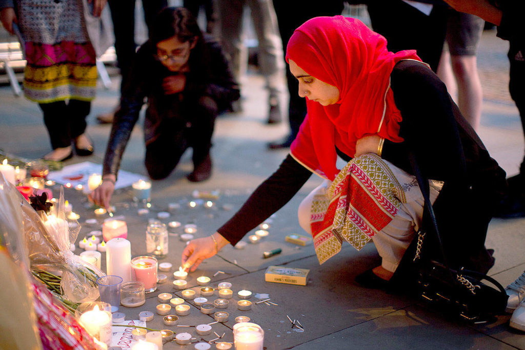 A woman lights candles after a vigil in Albert Square in Manchester, England, on Tuesday, the day after the suicide attack at an Ariana Grande concert that left 22 people dead. (AP Photo/Emilio Morenatti) 
