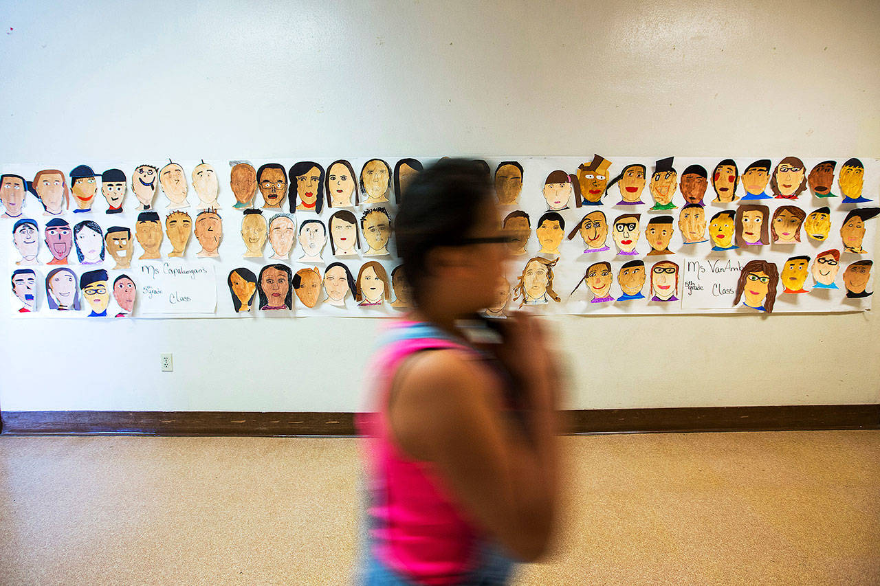A poster of self-portraits hand-painted by students is displayed in a hallway at Hoover Elementary School in Yakima. (Shawn Gust / Yakima Herald-Republic)