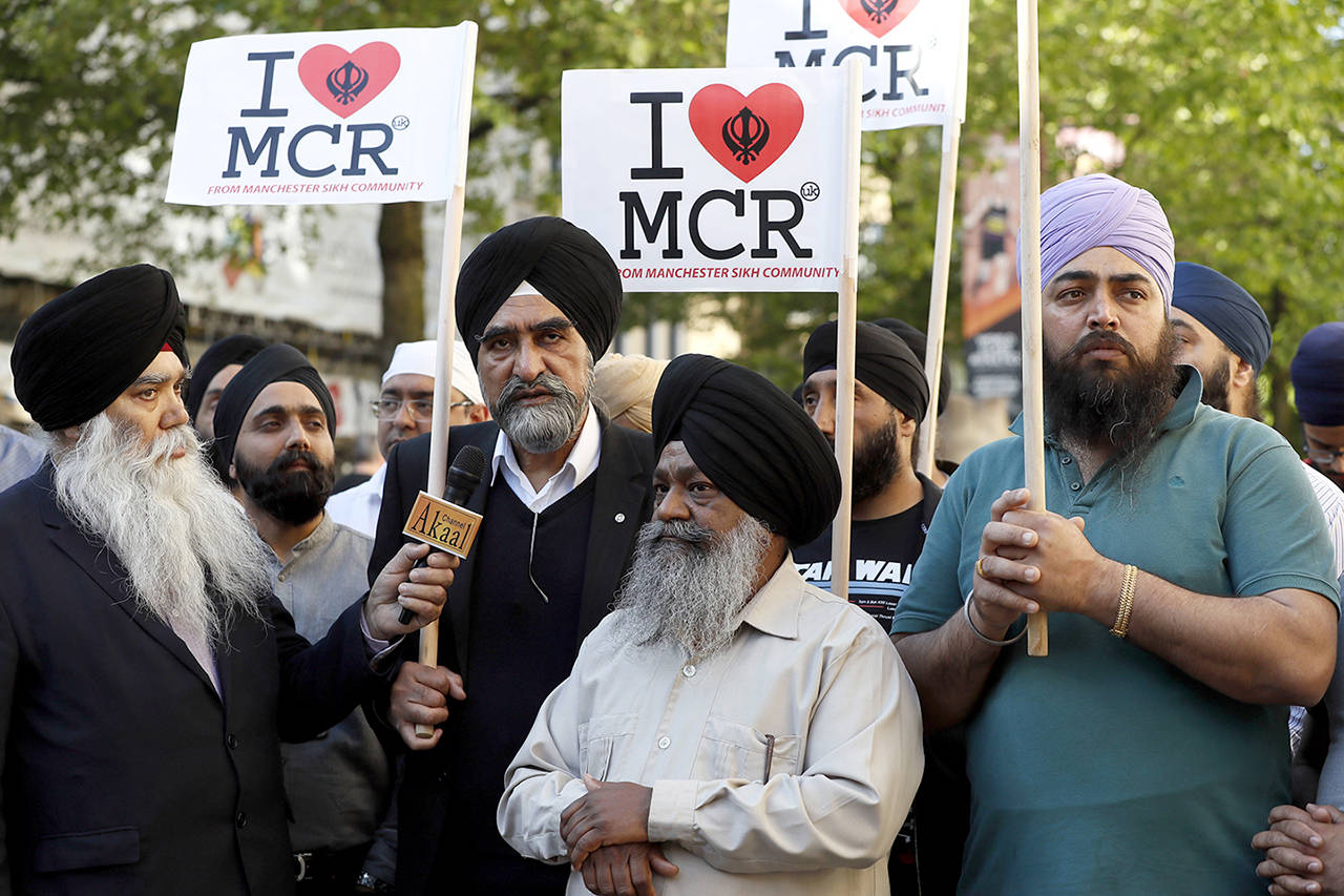 Members of the Manchester Sikh Community attend a vigil in Albert Square, Manchester, England, on Tuesday May 23, the day after the suicide attack at an Ariana Grande concert that left 22 people dead as it ended on Monday night. (AP Photo/Kirsty Wigglesworth)