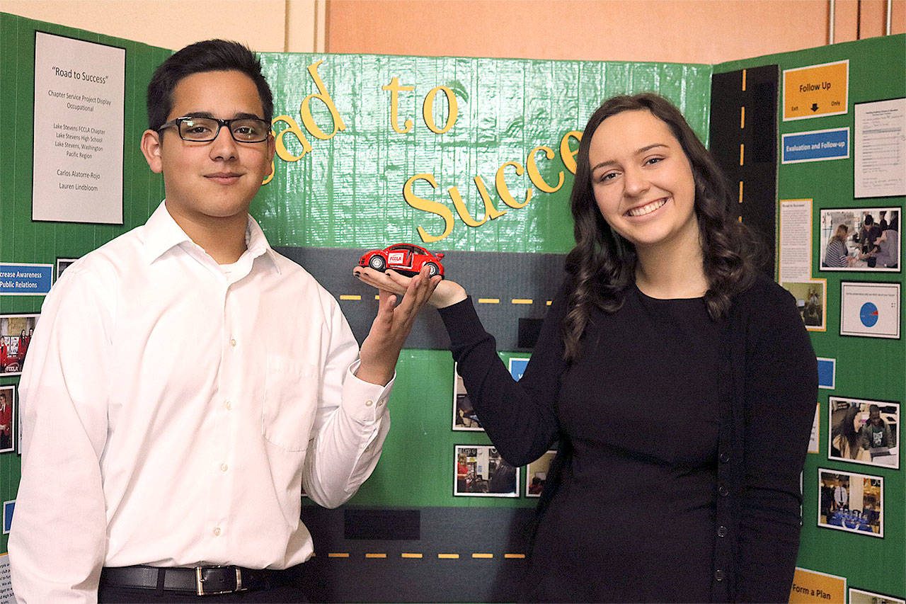 Lake Stevens High School students Carlos Alatorre-Rojo and Lauren Lindbloom share information about their FCCLA club’s “Road to Success” project. (Contributed photo)