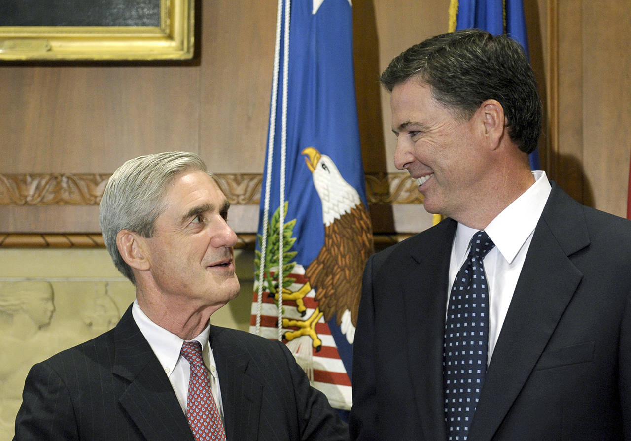 Then-incoming FBI Director James Comey (right) talks with outgoing FBI Director Robert Mueller before Comey was officially sworn in at the Justice Department in Washington in 2013. (Associated Press)
