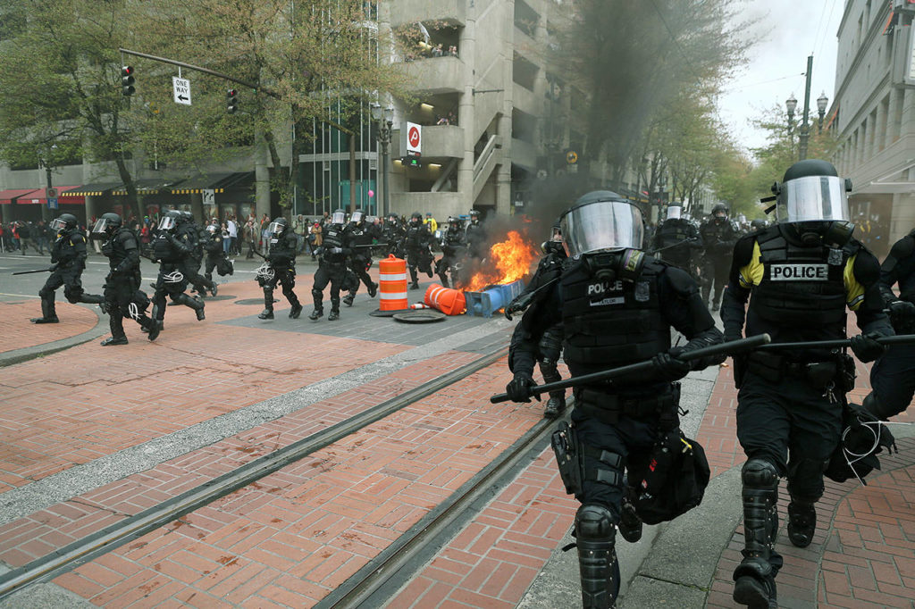 Police disperse people participating in a May Day rally in downtown Portland, Oregon, on Monday. Police in Portland said the permit obtained for the rally and march there was canceled as some marchers began throwing projectiles at officers. (Dave Killen/The Oregonian via AP)
