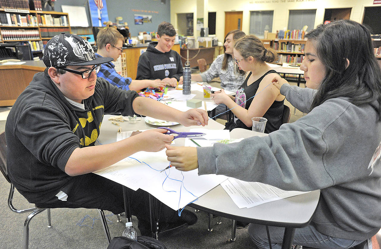 In this April 26 photo, Pepsimen group members fashion prototype products out of repurposed plastic for Lautenbach Industries during an innovation STEM project at Sedro-Woolley High School in Sedro-Woolley. (Scott Terrell/Skagit Valley Herald via AP)