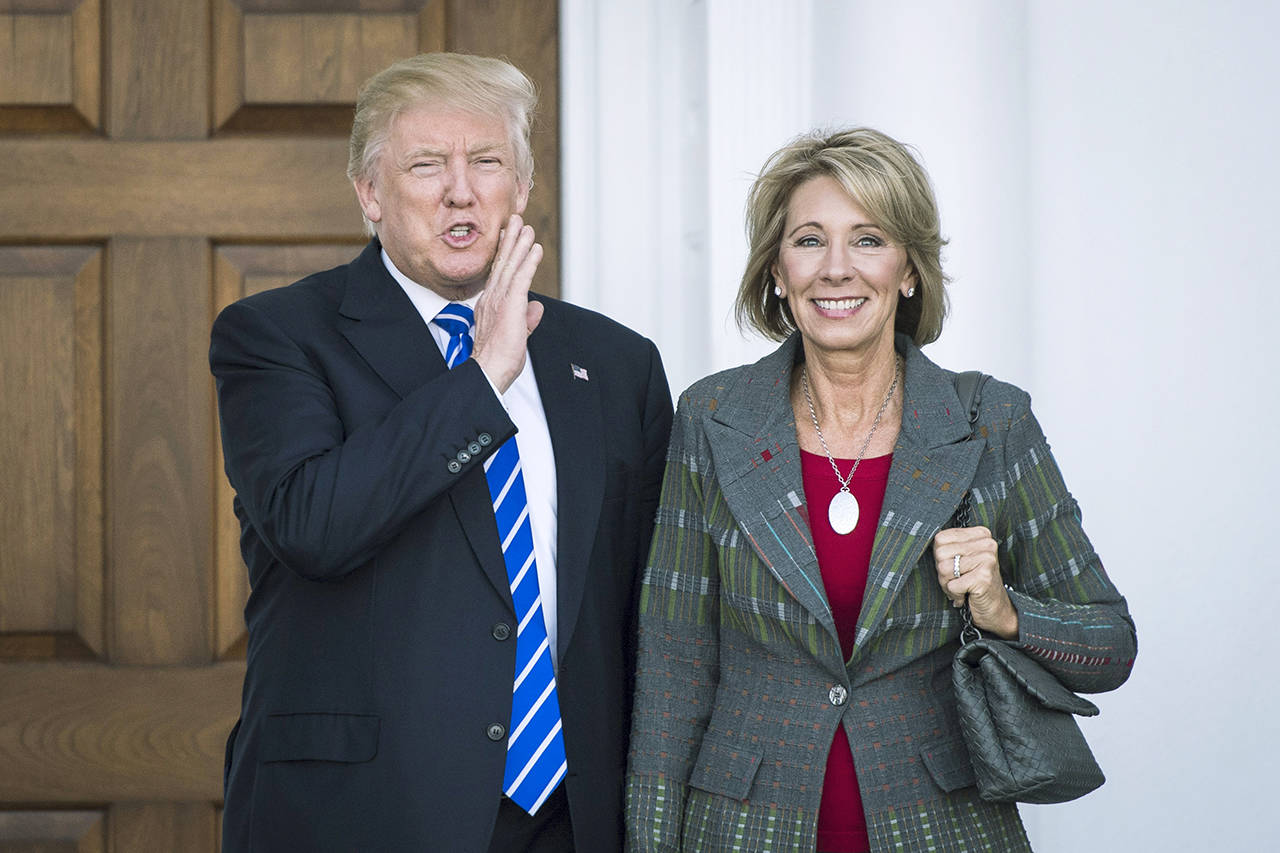 Donald Trump, then president-elect, stands with Betsy DeVos after a meeting in November 2016. (Jabin Botsford / Washington Post)