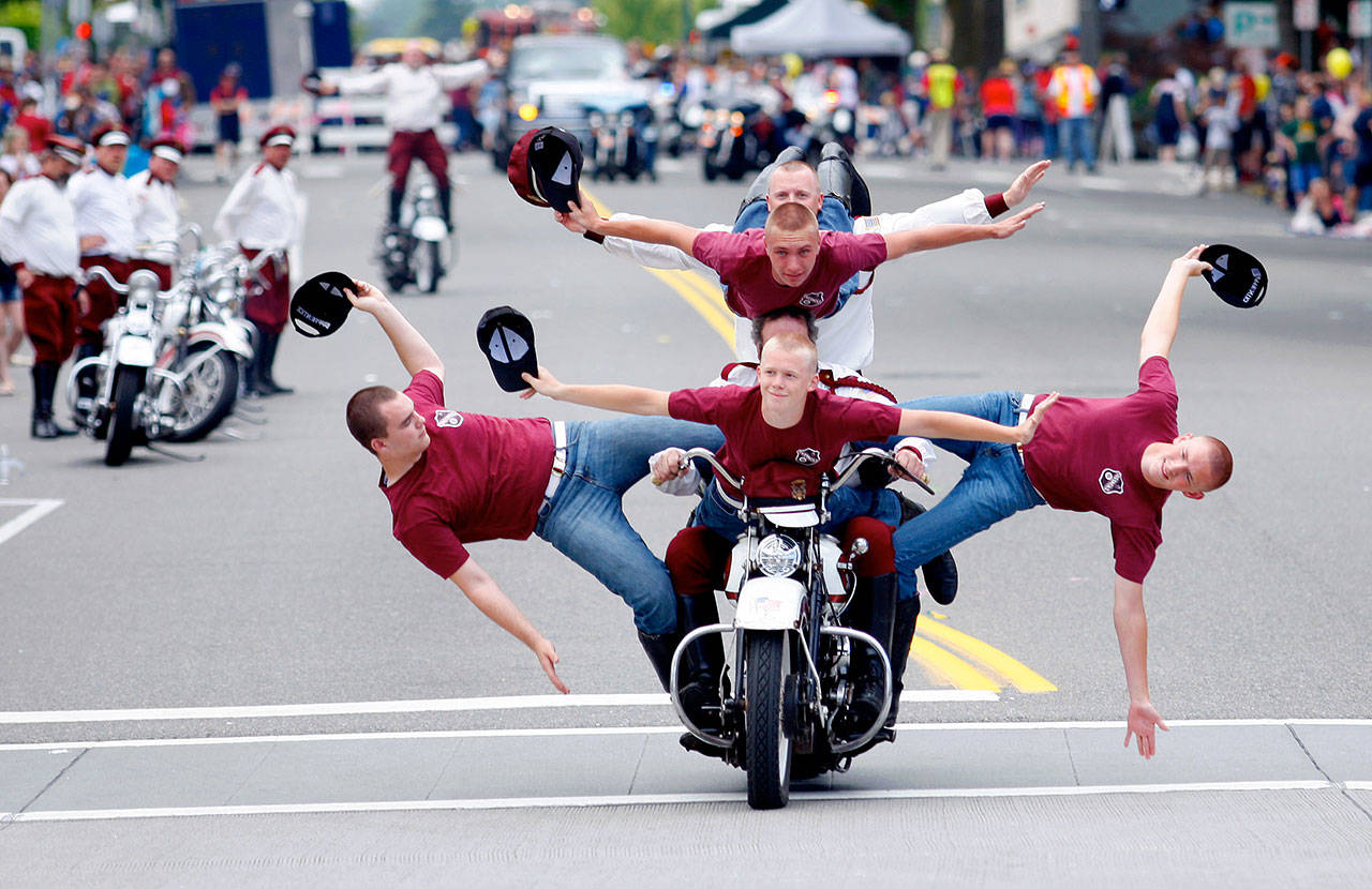 Members of the Seattle Cossacks motorcycle team perform a stunt at the Fourth of July parade in downtown Everett in 2013. (Herald file photo)
