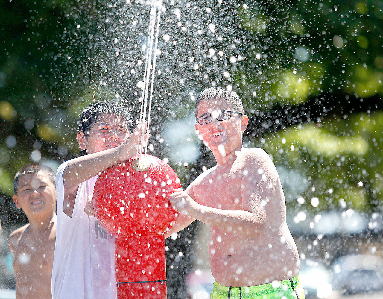 Isaias Komok, (center) and Zakary Wagner (right) aim a water cannon at Marysville’s Spray Park in Comeford Park in 2014. (Herald file photo)