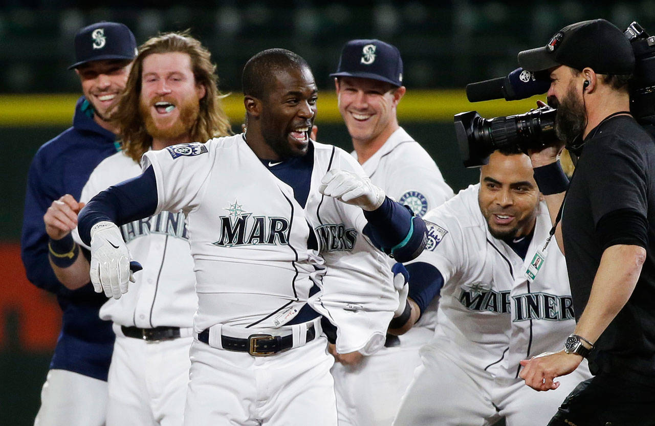 The Mariners’ Guillermo Heredia (front) is mobbed by teammates after hitting a walk-off single against the White Sox in a game May 18, 2017, in Seattle. (AP Photo/Ted S. Warren)