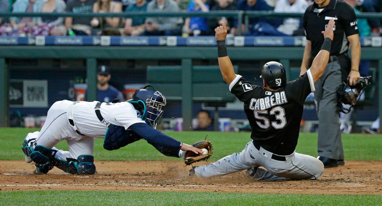 The White Sox’s Melky Cabrera (53) slides safely home to score on a double by Avisail Garcia despite the tag attempt from Mariners catcher Carlos Ruiz in the fourth inning of a game May 20, 2017, in Seattle. (AP Photo/Ted S. Warren)
