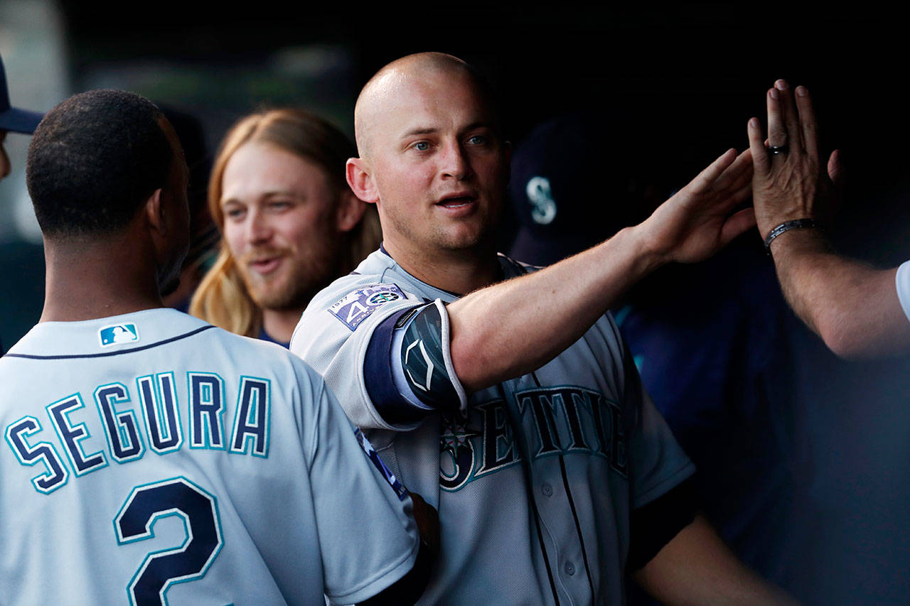 The Mariners’ Kyle Seager (center) is congratulated by teammates as he returns to the dugout after scoring against the Rockies in the third inning of a game May 30, 2017, in Denver. (AP Photo/David Zalubowski)