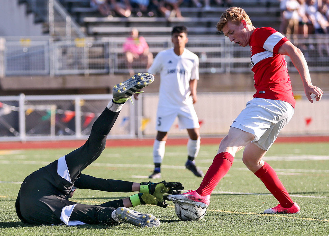 Archbishop Murphy’s Matt Williams (right) gathers a rebound from East Valley’s Chris Kirby to score a goal during the 2A state soccer championship match on May 27, 2017, at Sunset Chev Stadium in Sumner. (Kevin Clark / The Herald)