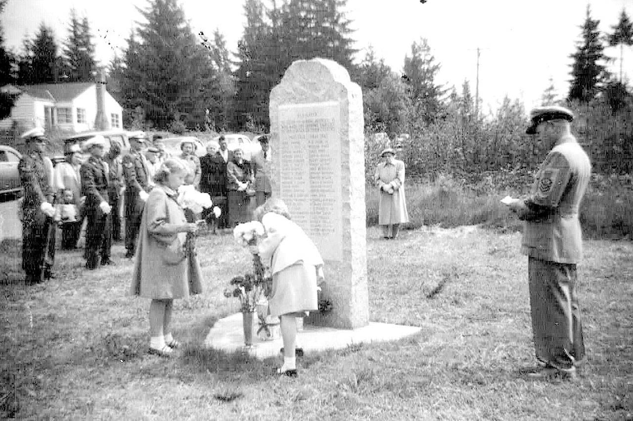 Patty Schoenholz (left) and Sheila Sievers lay flowers at the base of the veterans’ memorial monument on Memorial Day 1954. (Photo/ Lynnwood VFW Post 1040)