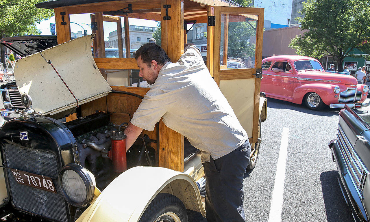 Allen McCutchen works on his 1922 Buick during the newly restored Cruzin Colby Sunday afternoon in downtown Everett on May 28, 2017. (Kevin Clark / The Herald)
