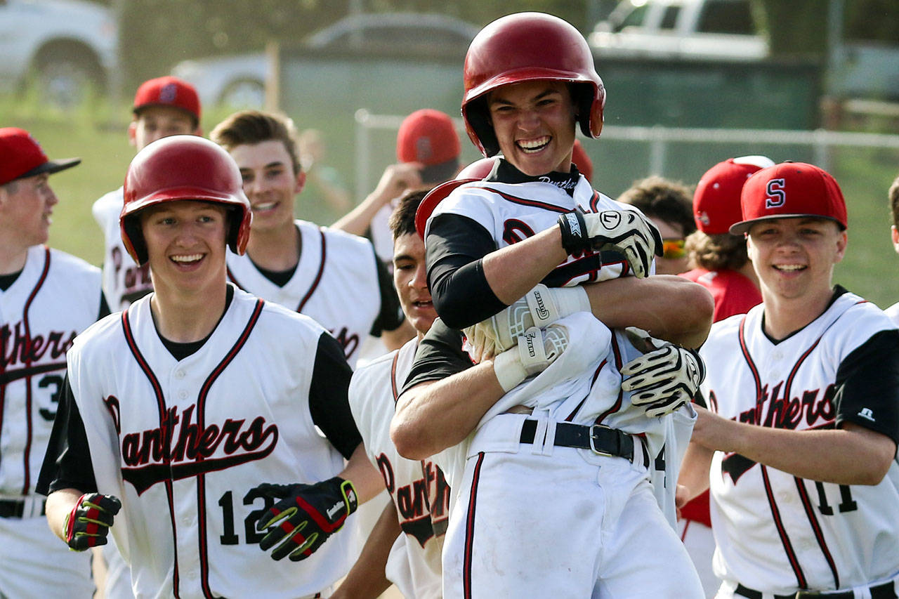 Snohomish’s Chase Taylor is lifted by teammate Josh Johnston after beating Marysville Pilchuck 5-4 in a winner-to-state, loser-out district game on May 10, 2017, at Earl Torgeson Field in Snohomish. (Kevin Clark / The Herald)