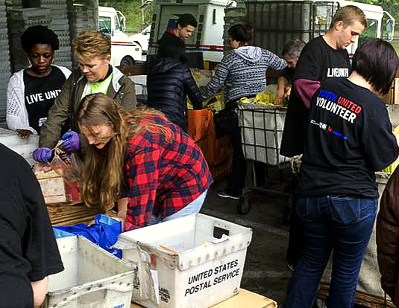 Volunteers unload bags of nonperishable food donated during the 2016 Letter Carriers Food Drive. Scheduled for May 13, the effort to help local food banks feed hungry people in Snohomish County will mark its 25th anniversary this year. (Volunteers of America Western Washington photo)