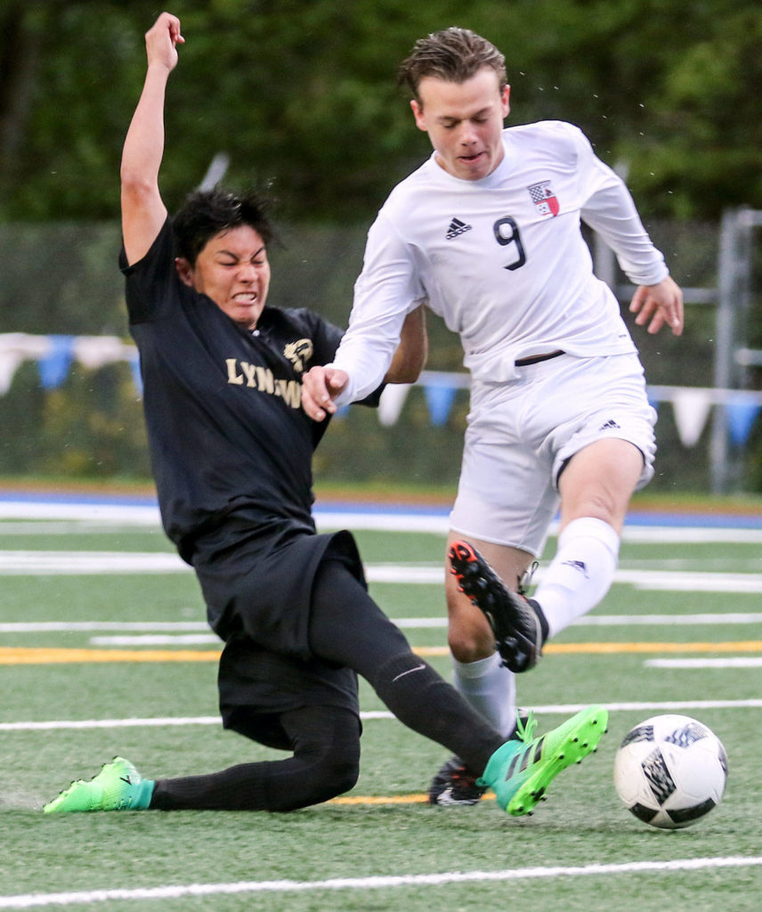 Lynnwood’s Patrick Kreider shoots and scores past Snohomish’s Owen Fieldler during Saturday’s 3A District 1 championship match Saturday in Shoreline. Lynnwood won 4-1. (Kevin Clark / The Herald)
