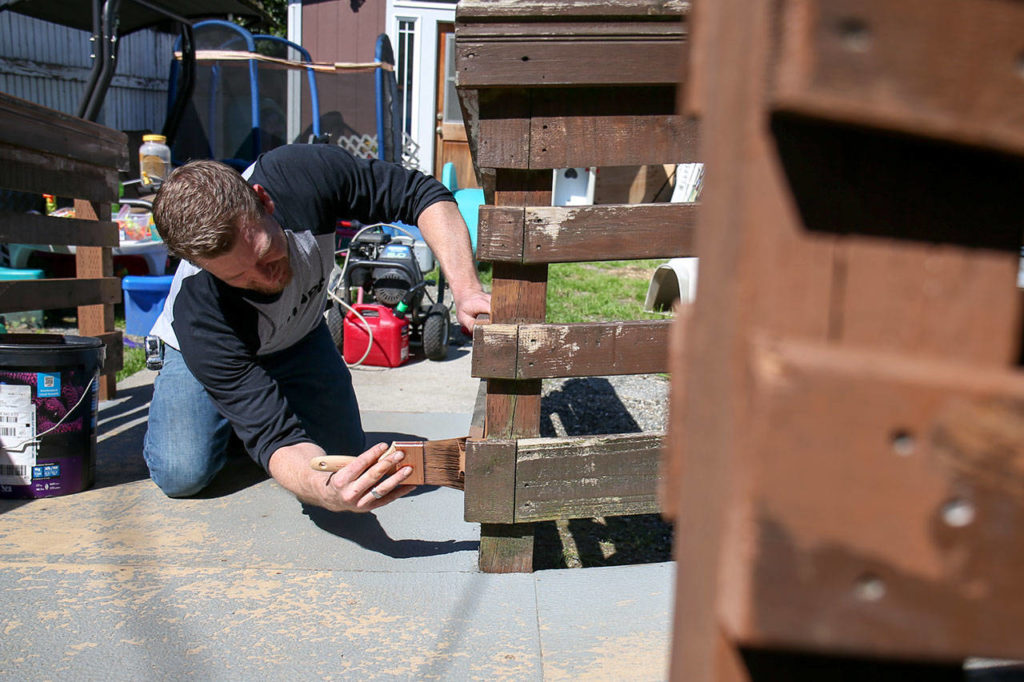 Bryan Gerrish paints a wheelchair ramp at a home in Lowell Saturday morning during the 3rd annual Day of Hope in Everett in May 20, 2017. Sponsored by Gold Creek Community Church, the two-day event drew nearly 1300 volunteers. (Kevin Clark / The Herald)
