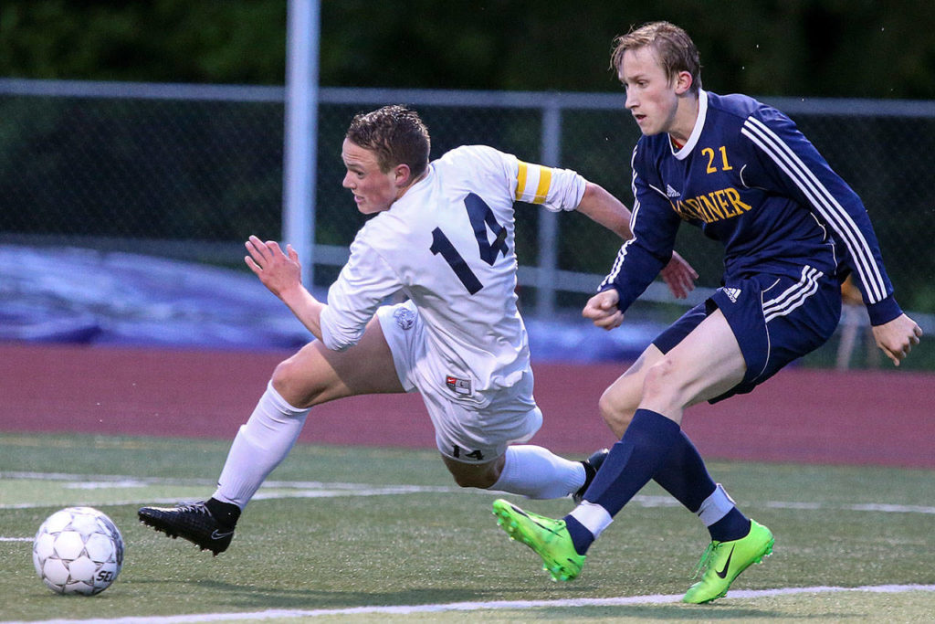 Glacier Peak’s Miles Johnston chases down the ball with Mariner’s Roman Voloshchuk trailing during the 4A District 1 title match on May 11, 2017, at Lake Stevens High School. (Kevin Clark / The Herald)
