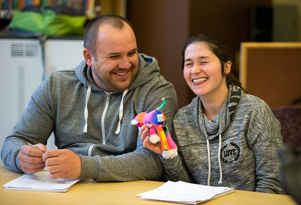 Holding Mikey the monkey, Ivan Ugnivyy and his wife Liliya laugh as she tries to find the right words to say during an ESL class in the library at Emerson Elementary on Monday, May 1, in Everett. The couple are from Ukraine. (Andy Bronson / The Herald)
