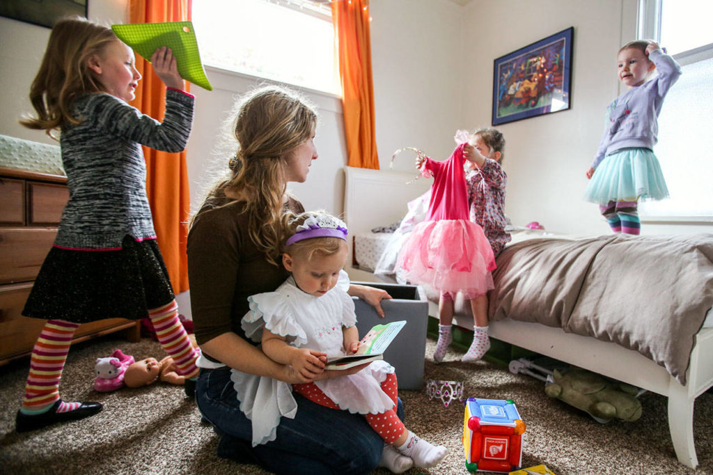 Cousins (from left) Nolah O’Brien, Luree Halbach and Anique Sims play with Rachel Halbach, holding her daughter, Alma Halbach. (Kevin Clark / The Herald)
