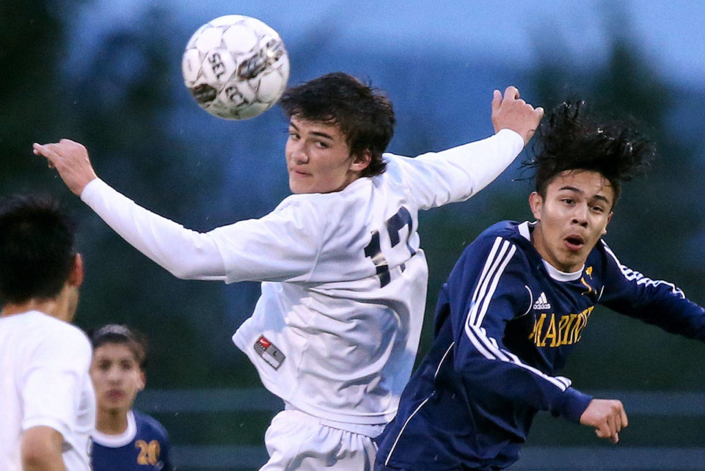 Glacier Peak’s Keegan Rubio (left) heads the ball with Mariner’s Edgar Tavares challenging during the 4A District 1 title match on May 11, 2017, at Lake Stevens High School. (Kevin Clark / The Herald)

